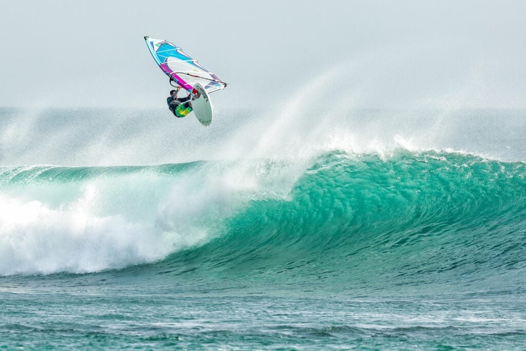 A windsurfer catching a rogue wave.