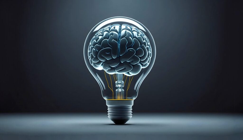 A brain inside of a light bulb showing both human mindset and AI.