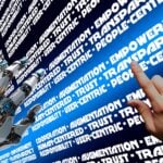 Robot hand and human hand hover over screen with collective intelligence phrases.