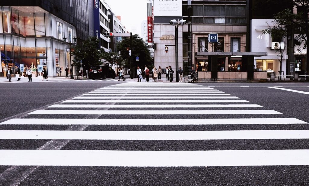 Large white crosswalk on busy city street.