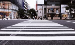 Large white crosswalk on busy city street.