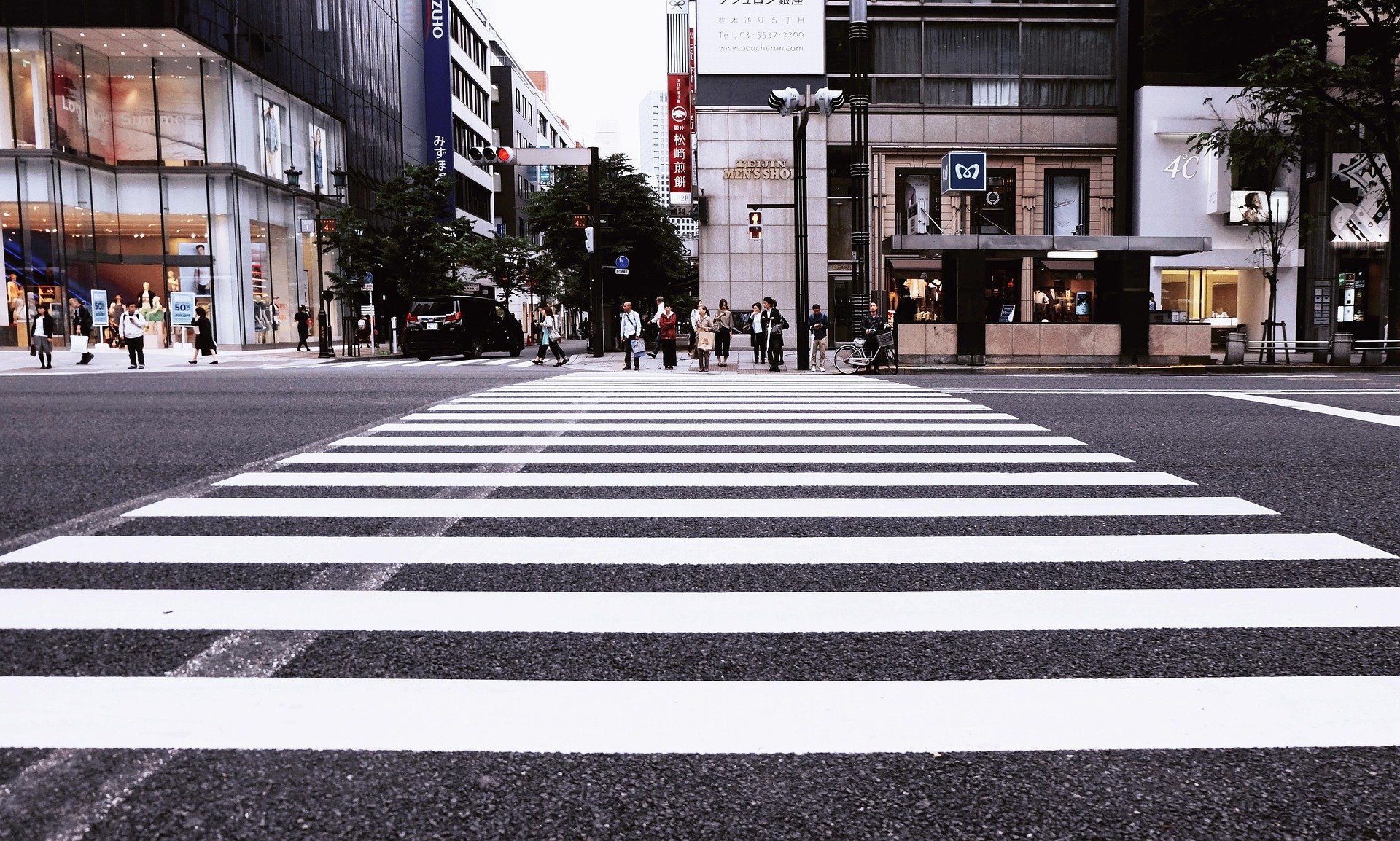 Large white crosswalk on busy city street.