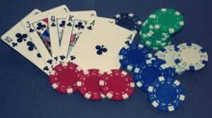 Playing cards showing royal flush, and with colorful poker chips.