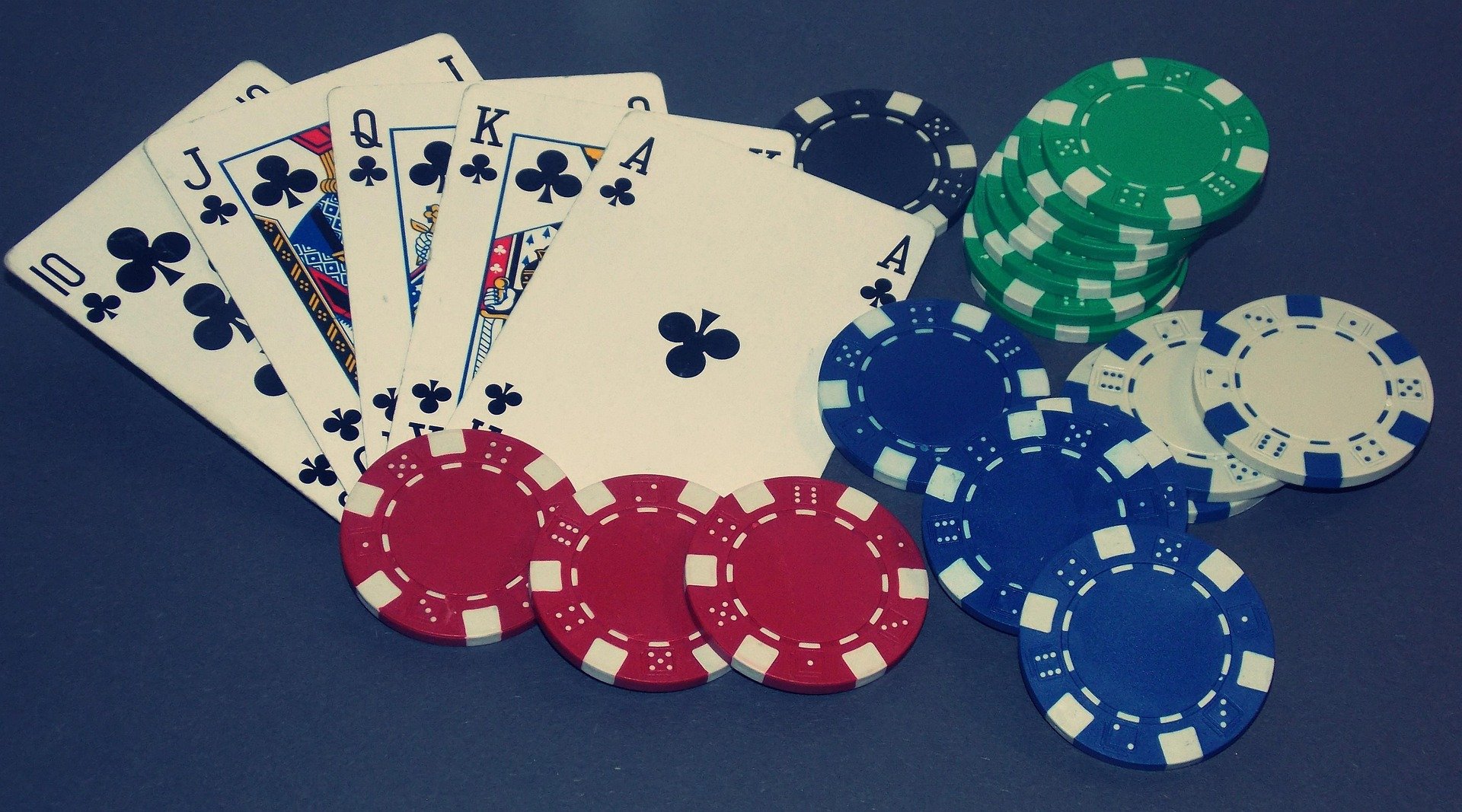 Playing cards showing royal flush, and with colorful poker chips.