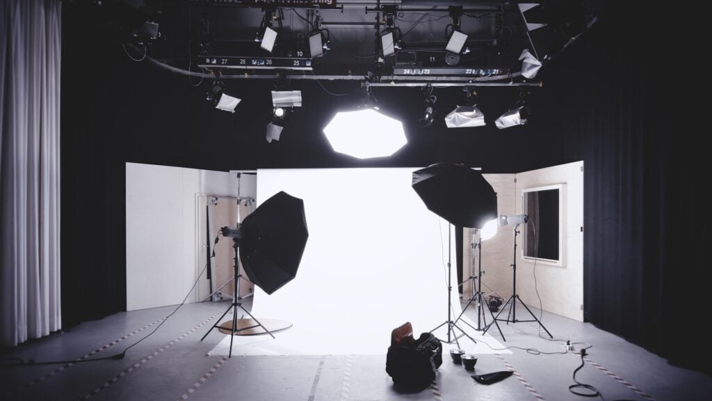 Behind the scenes of a multimedia studio, with background, lighting, camera.