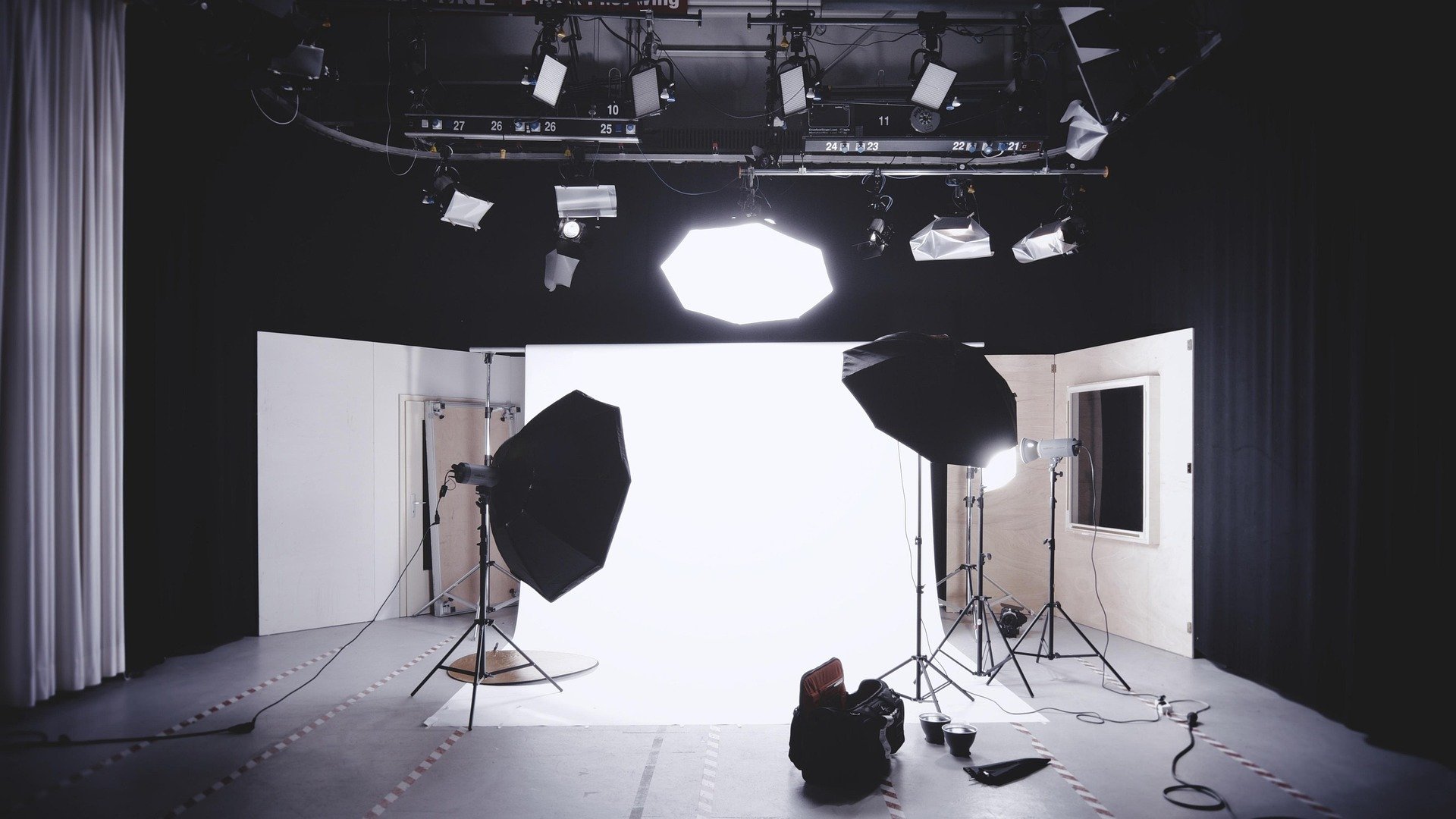Behind the scenes of a multimedia studio, with background, lighting, camera.