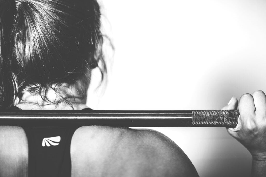 Strong woman athlete cross fit training with a weight bar.