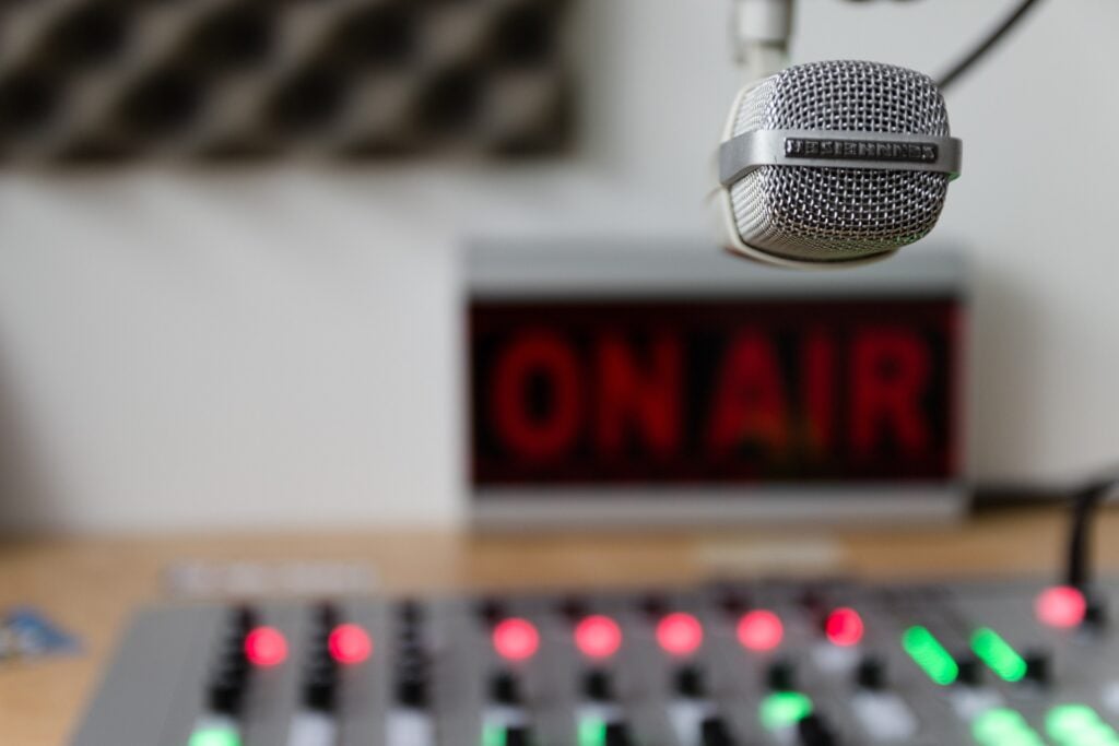 Radio or recording studio with on air sign, volume controls and microphone.