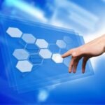 Hand touching a virtual or futuristic control panel on a wall screen.