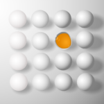 A grouping of white eggs, one of which is broken open and shows the yolk inside.