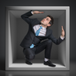 Businessman trapped in a small box, walls closing in.