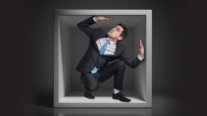 Businessman trapped in a small box, walls closing in.