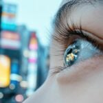City lights reflecting in a woman’s wide open eye.
