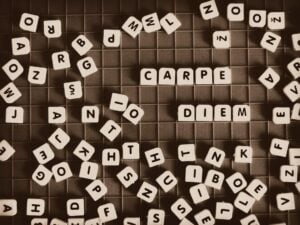 A jumble of block letters on a game board with Carpe Diem spelled out and standing out.