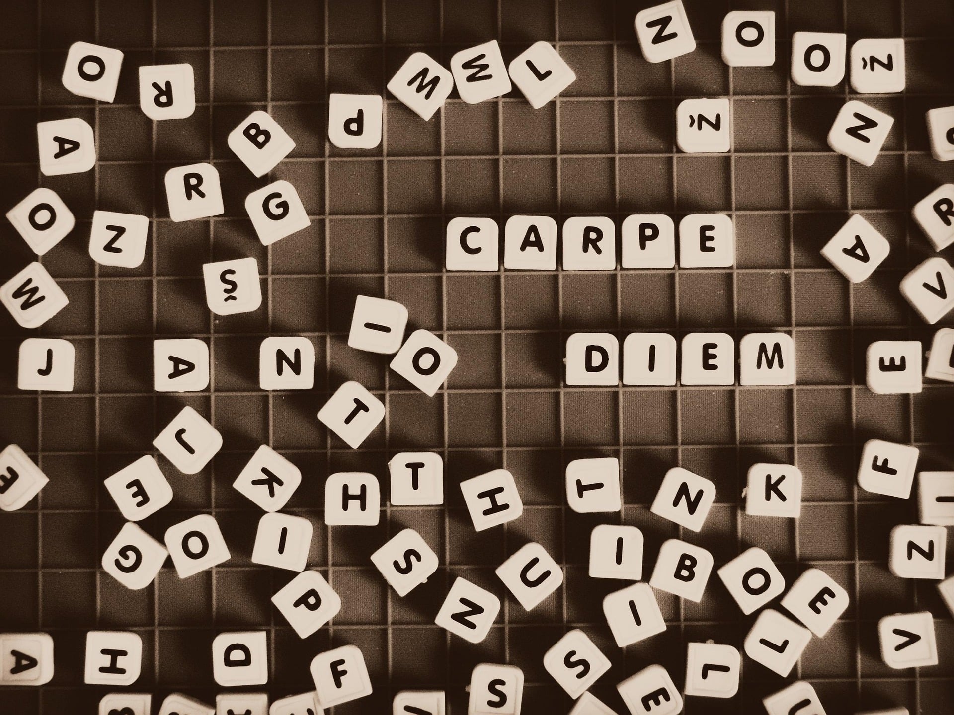 A jumble of block letters on a game board with Carpe Diem spelled out and standing out.